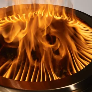 herQs rauchlose Feuerstelle mit hellen Flammen in einer runden Edelstahlschale und radial belüftetem Innenraum