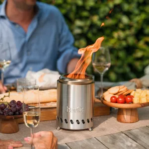 herQs Smokeless FirePit Mini tabletop fire pit with visible flame on an outdoor dining table