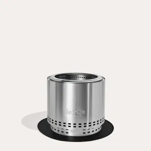 Tapis chauffant herQs Cozy & Blaze Grounder présenté sur une base cylindrique argentée avec logo en relief