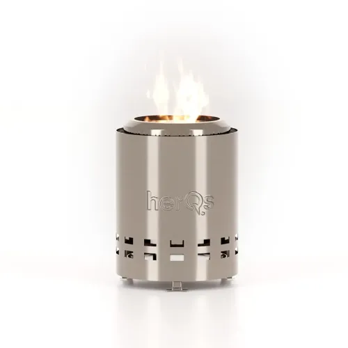 herQs Rökfri Eldstad Mighty, cylindrisk i rostfritt stål med utskuren logotyp, fyrkantiga luftslitsar och synlig låga ovanpå.