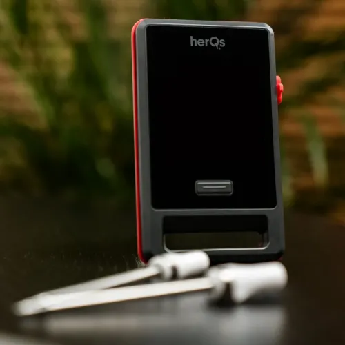 herQs Pin PRO trådlös kötttermometer med svart rektangulär front, röd kant, sidoknapp, nedre slits och två prober i förgrunden.